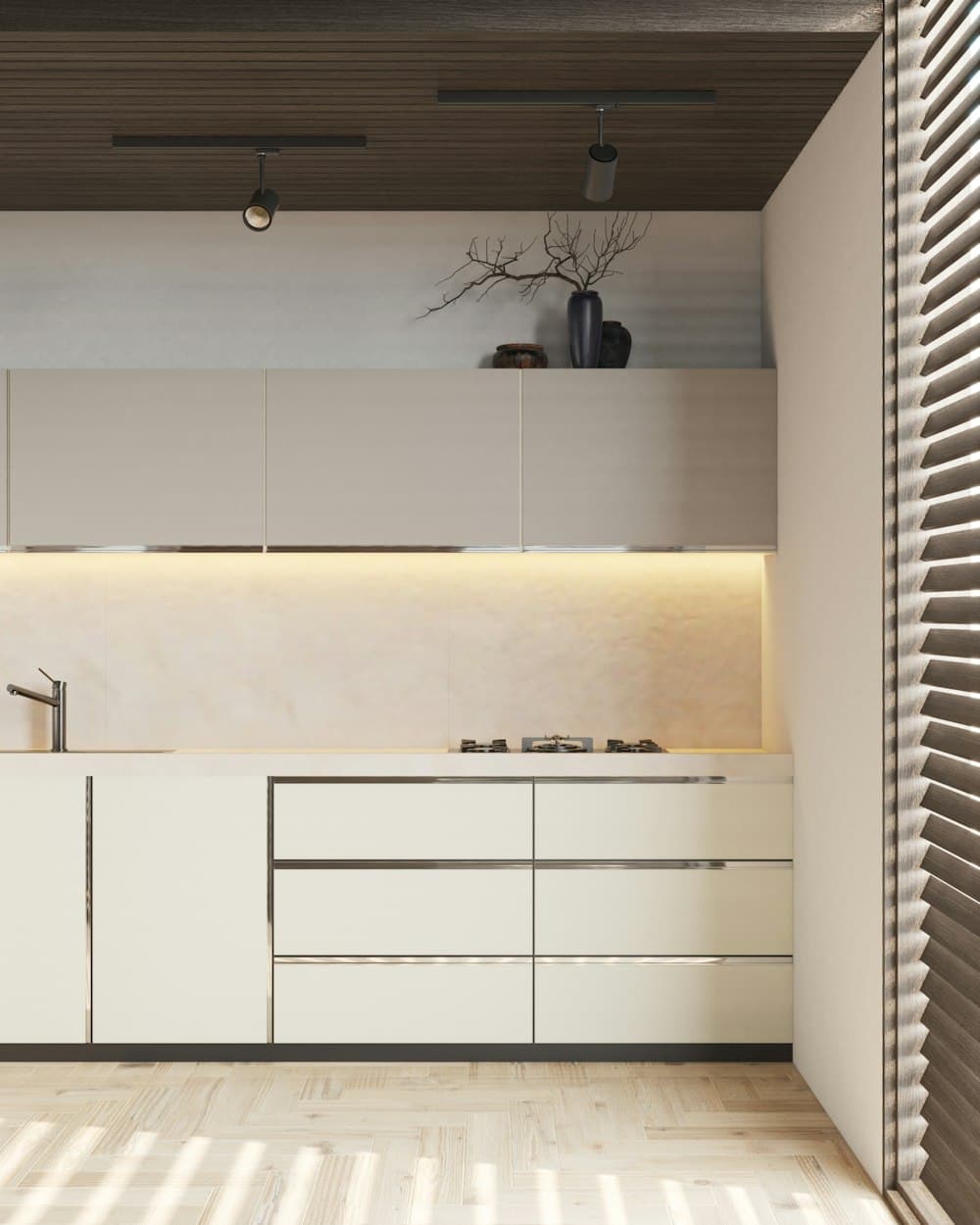 A minimal kitchen with pale handleless cabinetry, a clear worktop and light from a shuttered window.